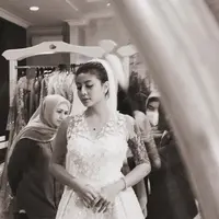 Dalam foto hitam yang diunggah Awkarin, ia memerlihatkan sedang fitting gaun pengantin bersama sang desainer Asky Febrianti. [@narinkovilda]