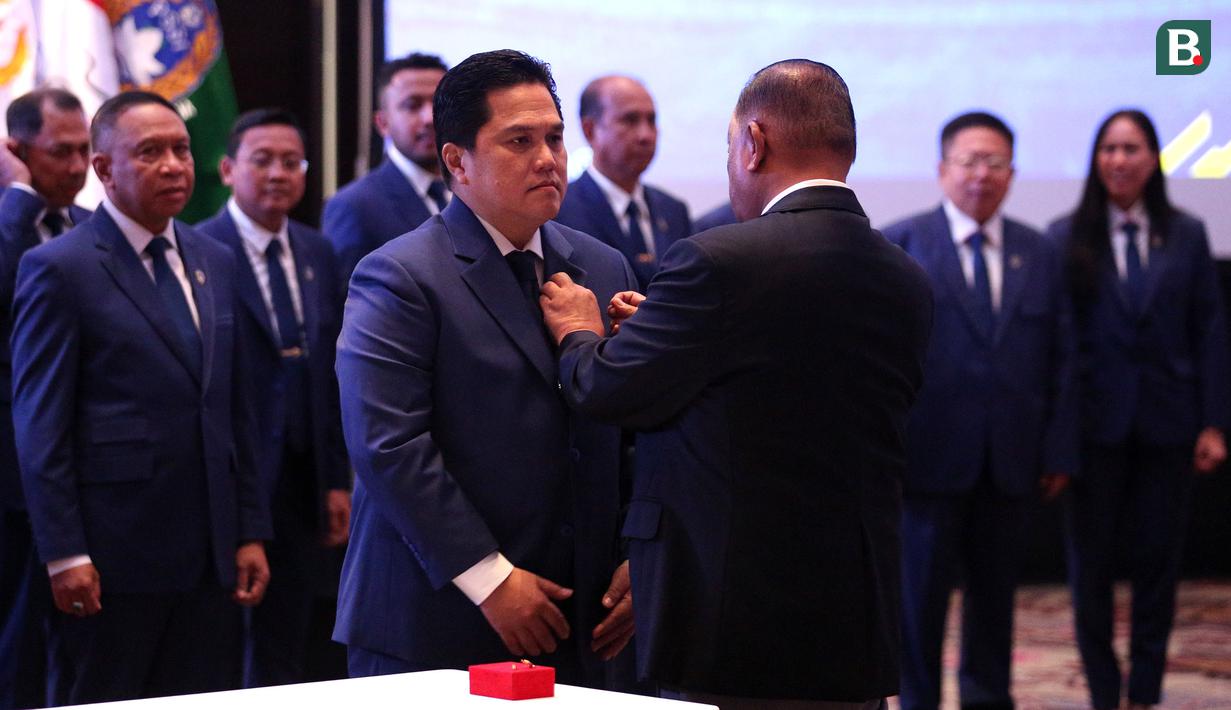 <p>Ketua KONI, Marciano Norman (kanan) menyematkan pin kepada Ketua Umum PSSI, Erick Thohir saat Pelantikan Pengurus PSSI Masa Bakti 2023-2027 yang berlangsung di Hotel Fairmont, Jakarta, Jumat (26/05/2023). (Bola.com/Bagaskara Lazuardi)</p>