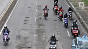 Kendaraan melintasi jalan berlubang di kawasan Gunung Sahari, Jakarta, Selasa (29/1). Sedikitnya terdapat 8 titik jalan rusak dan berlubang di sepanjang Jalan Gunung Sahari berdiameter hingga 10 cm dengan kedalaman 10 cm. (Merdeka.com/Iqbal S. Nugroho)