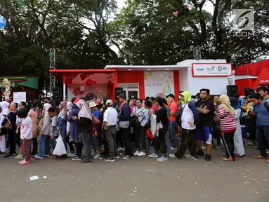 Pengunjung antre menuju Merchandise Superstore jelang Closing Ceremony Asian Games 2018 di kawasan Gelora Bung Karno, Jakarta, Minggu (2/9). Mereka rela antre untuk membeli suvenir, maskot, hingga kaus  Asian Games. (Liputan6.com/Fery Pradolo)