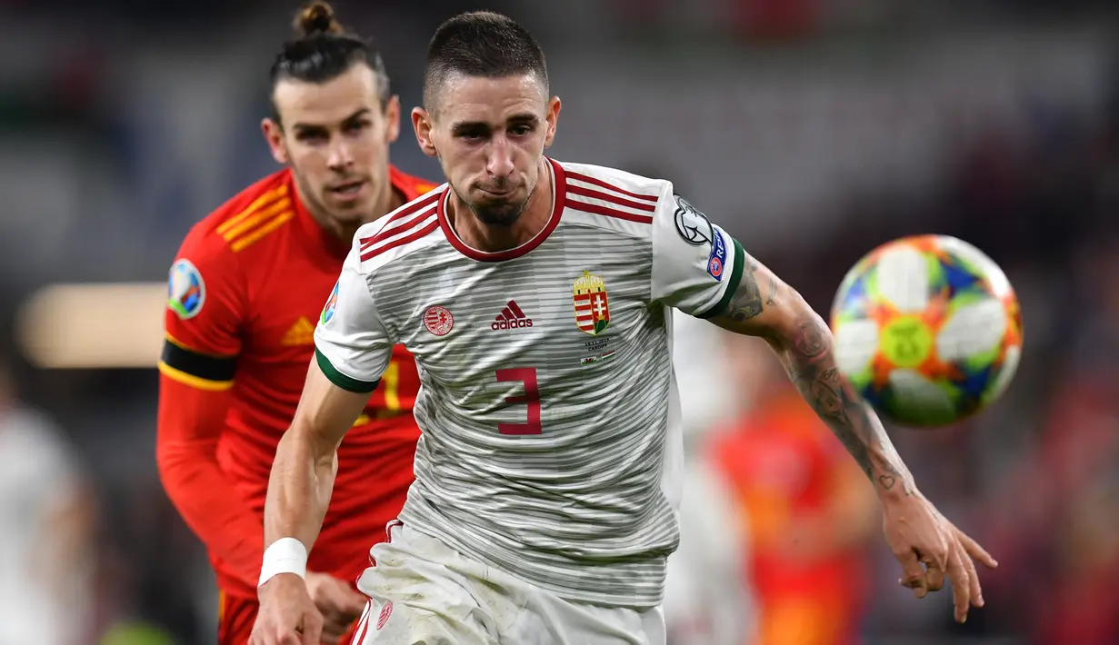 Bintang Timnas Wales, Gareth Bale, berebut bola dengan gelandang Hungaria, Dominik Nagy pada laga Grup E Kualifikasi Piala Eropa 2020 di Cardiff City Stadium, Selasa (19/11/2019). Wales memastikan satu tempat di putaran final Piala Eropa 2020 setelah mengalahkan Hungaria 2-0. (Paul ELLIS/AFP)