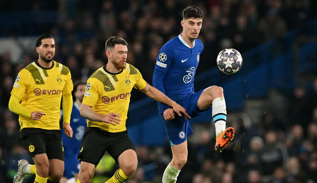 Pemain Chelsea, Kai Havertz (kanan) berusaha mengontrol bola dibayangi pemain Borussia Dortmund pada laga leg kedua 16 Besar Liga Champions 2022/2023 yang berlangsung di Stamford Bridge, London, Rabu (08/03/2023) WIB. The Blues berhasil melaju ke babak perempat final setelah menang dengan agregat 2-1. (AFP/Glyn Kirk)