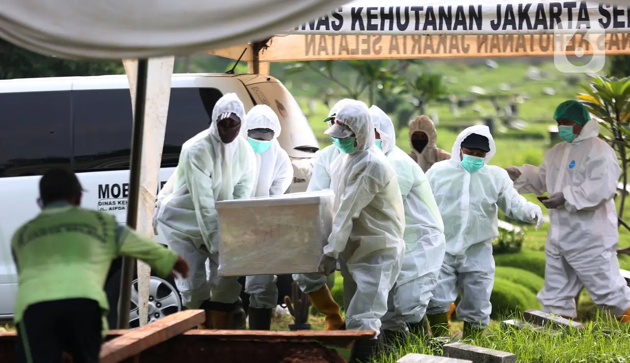 Petugas membawa jenazah presenter Rina Gunawan saat prosesi pemakaman di TPU Tanah Kusir, Jakarta, Rabu (3/3/2021). Istri Teddy Syach ini sempat terinfeksi COVID-19 dan kondisinya cukup buruk karena memiliki penyakit bawaan. (Kapanlagi.com/Budy Santoso)