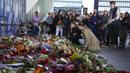 Orang-orang meletakkan bunga untuk mengenang para korban pada pintu masuk pusat perbelanjaan Field di Kopenhagen, Denmark, 5 Juli 2022. Polisi mengesampingkan bahwa serangan hari Minggu itu terkait dengan terorisme. (AP Photo/Sergei Grits)