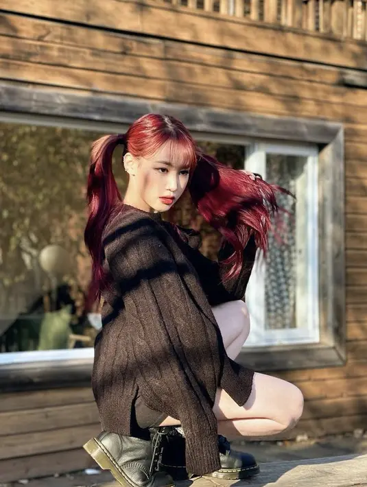 Rambut merah menyalanya pun menjadi on point ketika ia mengenakan sweater rajut hitam diapdukan dengan short pants dan sepatu boots hitam.(@jiminxjamie)
