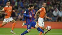 Bintang Barcelona, Lionel Messi, berusaha melewati pemain Osasuna pada laga La Liga di Stadion Camp Nou, Barcelona, Rabu (26/4/2017). Barcelona menang 7-1 atas Osasuna. (AFP/Lluis Gene)