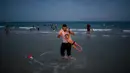 Warga Palestina dan putranya bermain di pantai selama libur Idul Fitri di Tel Aviv, Israel, Sabtu (16/6). (AP Photo/Oded Balilty)