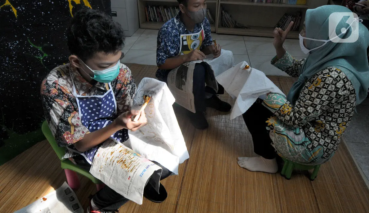 Anak berkebutuhan khusus (ABK) penyandang tunarungu belajar membatik yang diselenggarakan oleh Yayasan Griya Bina Karya di gerai ABK UMKM di Pasar Gintung, Ciputat, Tangsel, Minggu (2/10/2021). Kegiatan ini dalam rangka memperingati Hari batik Nasional 2 Oktober. (merdeka.com/Arie Basuki)