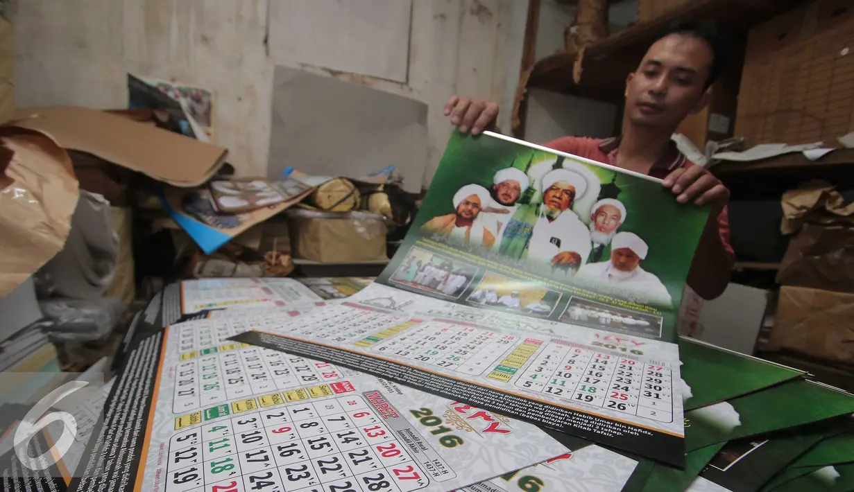 Pekerja memperlihatkan kalender 2016 di Jakarta, Rabu (25/11). Jelang taun 2016 permintaan pemesanan kalender meningkat sebesar 100%, mayoritas pemesanan berasal dari perkantoran dan hotel. (Liputan6.com/Angga Yunuar)