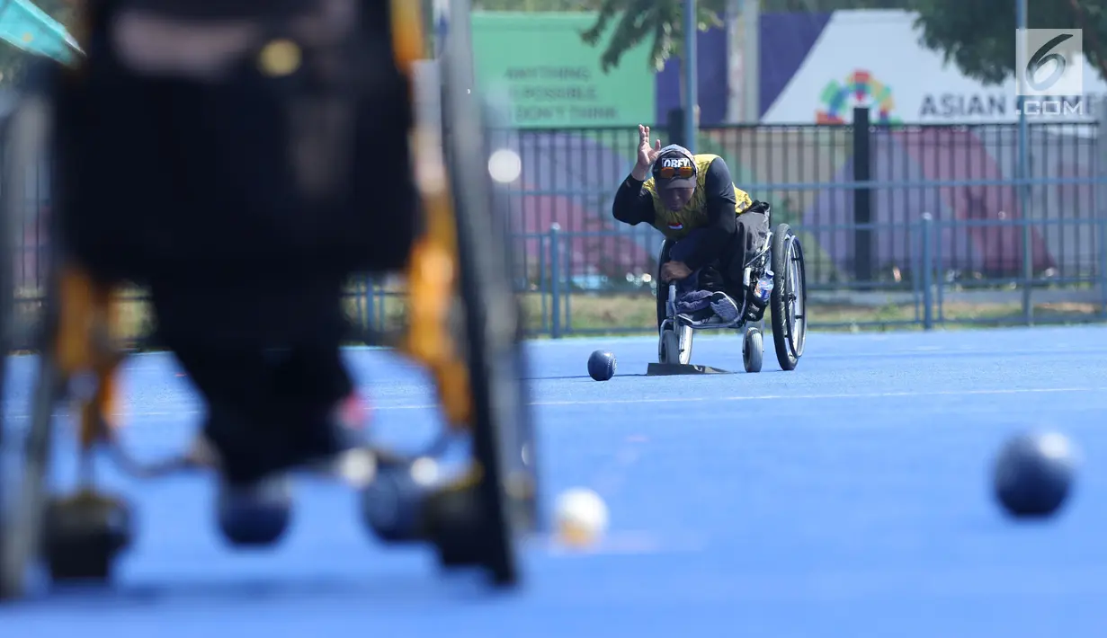 Atlet Para Games Indonesia cabang olahraga Lawn Bowls melakukan lemparan saat latihan di Lapangan Hoki Kompleks GBK, Jakarta, Selasa (18/9). Latihan ini adaptasi lapangan sekaligus persiapan jelang Asian Para Games 2018. (Liputan6.com/Helmi Fithriansyah)