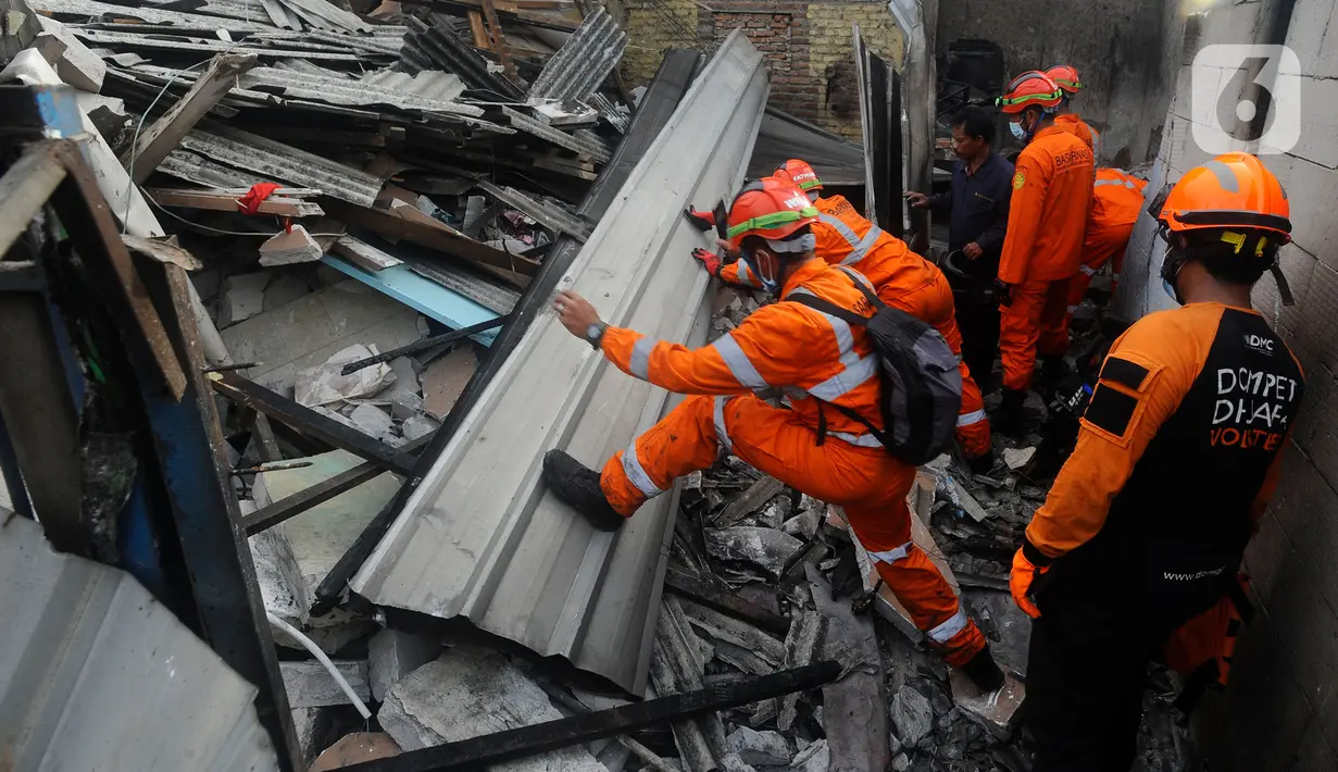 Petugas Basarnas menyisir lokasi rumah warga yang hancur akibat kebakaran hebat Depo Pertamina Plumpang, Koja, Jakarta Utara, Sabtu (4/3/2023) pagi. Kobaran api membumbung tinggi dan membuat langit di sekitar lokasi kejadian menjadi gelap karena tertutup asap hitam. (merdeka.com/Arie Basuki)
