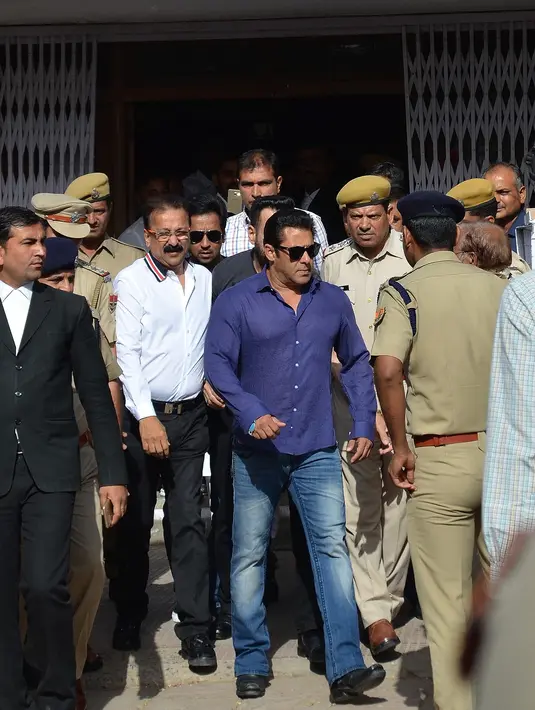 Aktor Bollywood India Salman Khan keluar dari sebuah pengadilan di Jodhpur, India (7/5). Salman Khan didampingi tim kuasa hukumnya menyambangi pengadilan tersebut untuk melakukan penangguhan gugatan. (STR/AFP)