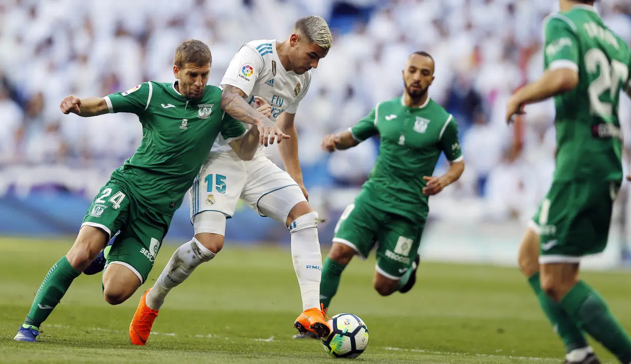 Bek Real Madrid, Theo Hernandez, berusaha melewati pemain Leganes, Darko Brasanac, pada laga La Liga di Santiago Bernabeu, Sabtu (28/4/2018). Real Madrid menang 2-1 atas Leganes. (AP/Francisco Seco)