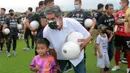 Coach Teco juga menyempatkan diri berfoto bersama salah satu pesepak bola cilik yang hadir di Training Ground Bali United. (Bola.com/ M Iqbal Ichsan)