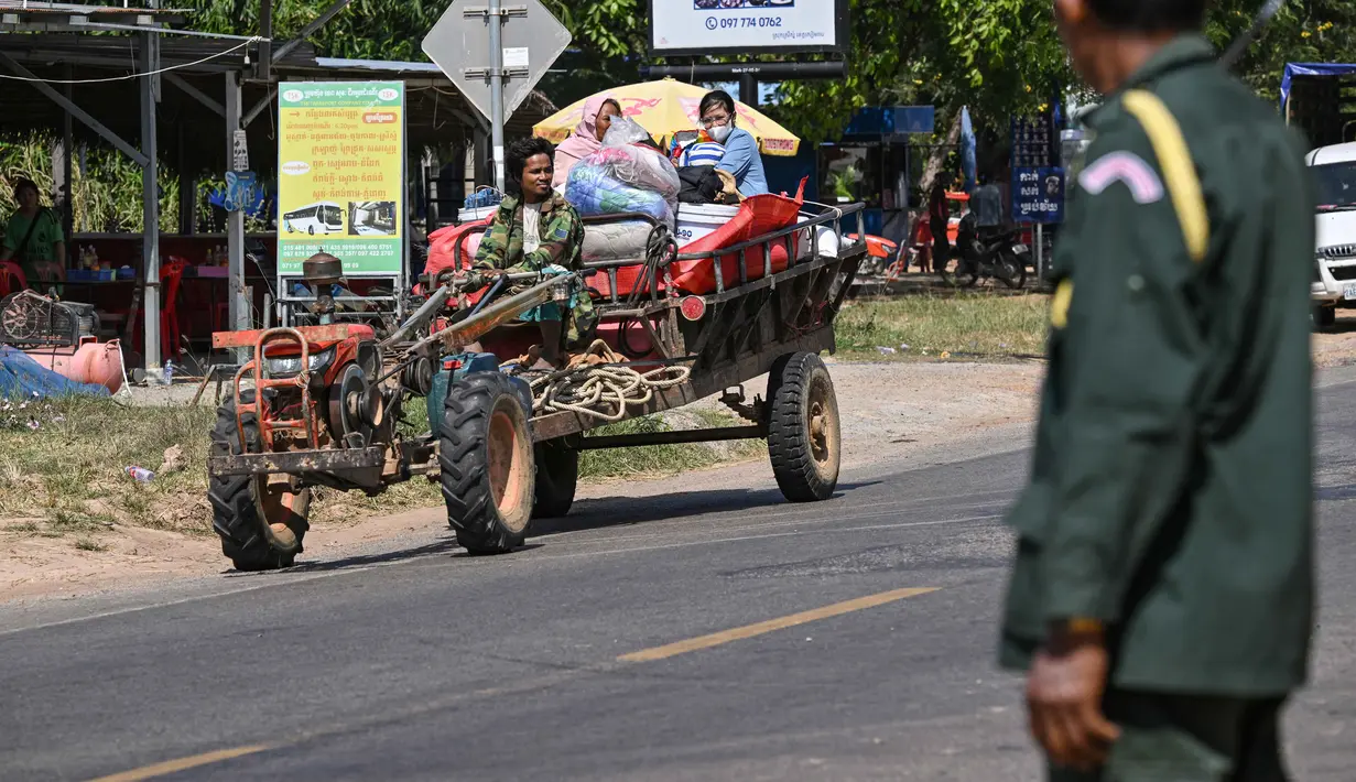 Konflik perbatasan ini berakar pada perselisihan wilayah sepanjang 817 kilometer yang telah berlangsung lebih dari satu abad atau sejak batas wilayah dipetakan oleh Prancis pada tahun 1907. Tampak dalam foto, seorang polisi (kanan) berdiri saat warga dievakuasi menyusul bentrokan di sepanjang perbatasan Kamboja-Thailand di Provinsi Siem Reap pada Selasa 9 Desember 2025. (TANG CHHIN SOTHY/AFP)