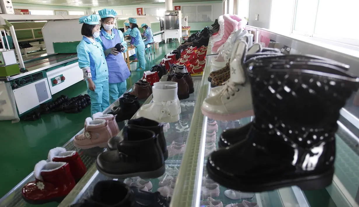 Sepatu-sepatu dipajang saat para pekerja yang memakai masker bekerja di Pabrik Sepatu Kulit Wonsan, tempat mereka memproduksi sepatu kulit buatan tangan di Wonsan, Provinsi Kangwon, Korea Utara pada 28 Oktober 2020. (AP Photo/Jon Chol Jin)