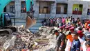 Warga melihat proses pengangkatan puing oleh eskavator di Pasar Meureudu yang hancur usai gempa, Pidie Jaya, Aceh, Kamis (8/12). Banyak bangunan di Aceh yang ambruk oleh gempa berkekuatan 6,4 SR. (Liputan6.com/Angga Yuniar)