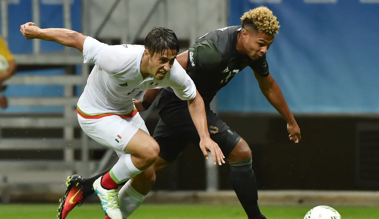Pemain Meksiko, Jose Abella (kiri), berebut bola dengan pemain Jerman, Serge Gnabry, pada laga perdana Grup C Olimpiade Rio 2016 di Arena Fonte Nova, Jumat (5/8/2016) dini hari WIB. (AFP/Nelson Almeida)