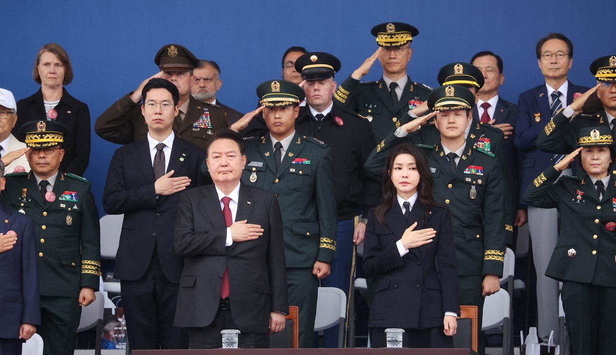 Presiden Korea Selatan Yoon Suk Yeol (tengah depan kiri) dan istrinya Kim Keon Hee memberi hormat kepada bendera nasional dalam upacara peringatan ke-75 Hari Angkatan Bersenjata Korea di Seongnam pada tanggal 26 September 2023. (KIM HONG-JI/POOL/AFP)
