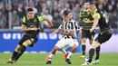 Striker Juventus, Paulo Dybala, berusaha melewati kepungan pemain Sporting Lisbon pada laga Liga Champions di Stadion Allianz, Turin, Rabu (18/10/2017). Juventus menang 2-1 atas Sporting. (AP/Alessandro Di Marco)
