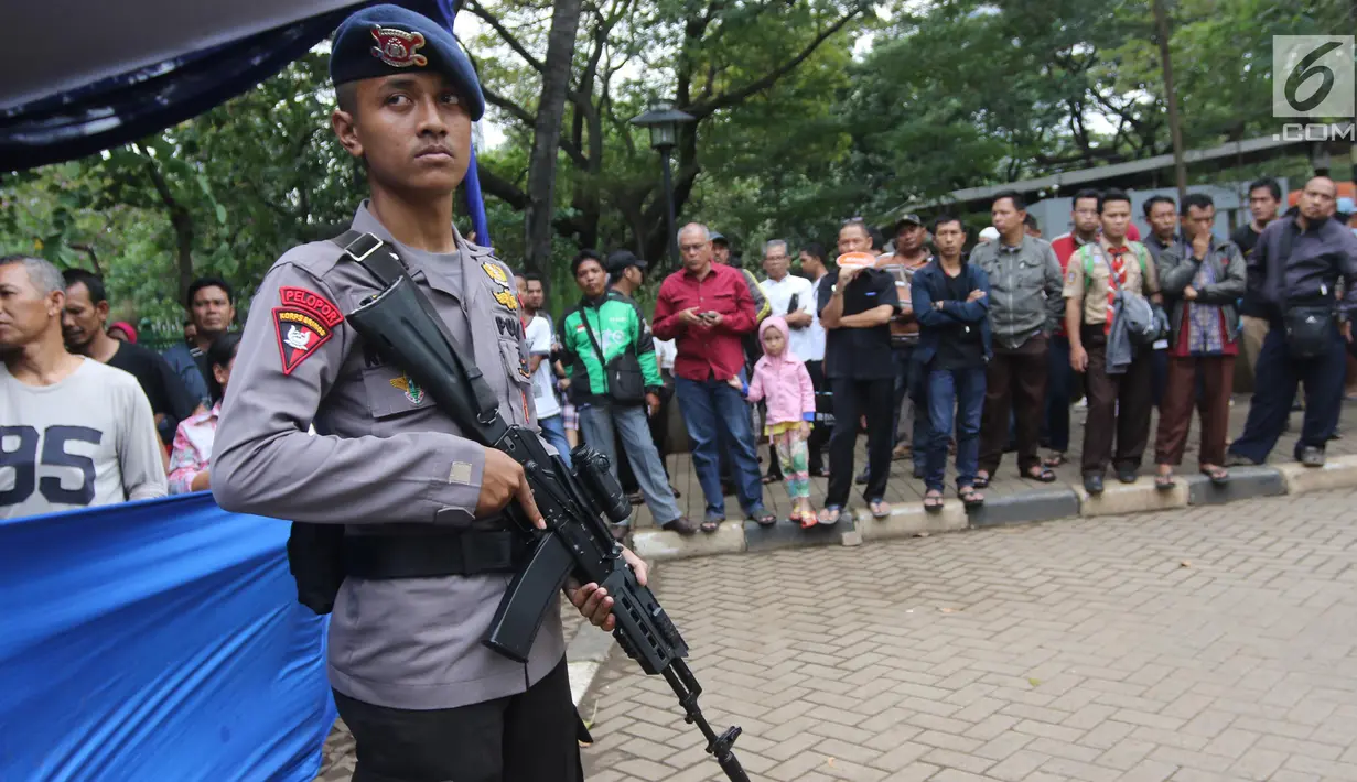 Polisi bersenjata melakukan penjagaan saat kegiatan penukaran uang pecahan di Lapangan IRTI Monas, Jakarta, Rabu (23/5). Penukaran uang pecahan kecil di IRTI Monas dilakukan dari 21-25 Mei sejak pukul 08.00-14.00 WIB. (Liputan6.com/Arya Manggala)