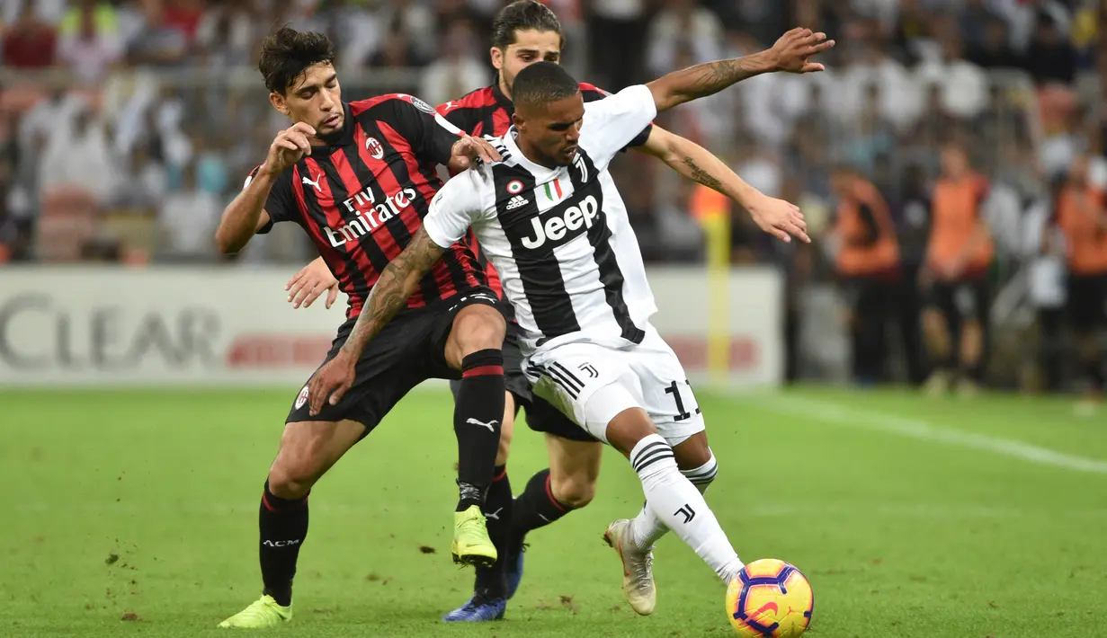 Pemain Juventus, Douglas Costa (kanan) berebut bola dengan pemain AC Milan, Lucas Paqueta (kiri) pada laga final di King Abdullah Sports City, Kamis (17/1). Juventus keluar sebagai kampiun dengan meraih kemenangan tipis 1-0. (Fayez Nureldine / AFP)