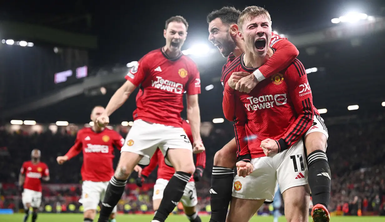 Pemain Manchester United, Rasmus Hojlund, melakukan selebrasi setelah mencetak gol ke gawang Aston Villa pada pekan ke-19 Premier League 2023/2024 di Stadion Old Trafford, Rabu (27/12/2023). Hojlund tampak begitu emosional merayakan gol perdananya tersebut. (AFP/Oli Scarff)