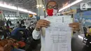 Calon penumpang dengan izin khusus melakukan perjalanan bisnis menunjukan surat syarat terbang di Terminal 3 Bandara Soekarno Hatta, Tangerang, Kamis (7/5/2020). Pemerintah melalui kementerian Perhubungan membuka kembali penerbangan domestik dengan penumpang bersyarat. (Liputan6.com/Herman Zakharia)