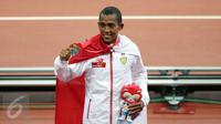 Pelari Indonesia, Agus Prayogo memamerkan medalinya di podium kemenangan di National Stadium, Singapura, Rabu (10/6/2015). Agus berhasil meraih emas di nomor lari 10.000 m putra SEA Games 2015. (Liputan6.com/Helmi Fithriansyah)