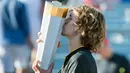 Petenis Jerman, Alexander Zverev mencium trofi usai meraih gelar juara Piala Rogers 2017 di Montreal, Minggu (13/8). Zverev menjadi petenis Jerman pertama sejak 1987 yang mampu juara di Rogers Cup kategori putra. (Paul Chiasson/The Canadian Press via AP)