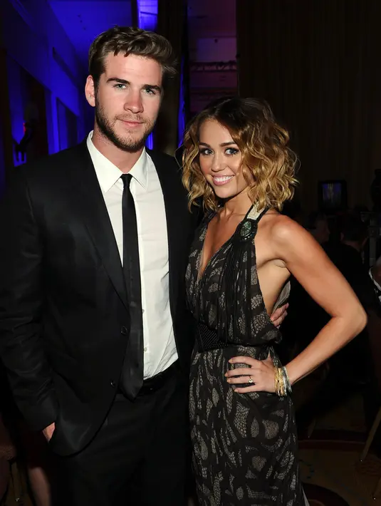 Di postingannya yang lainnya Cyrus dan Liam berpose dengan wajah jenaka di depan karya Vijat Mohindra. (AFP/Bintang.com)