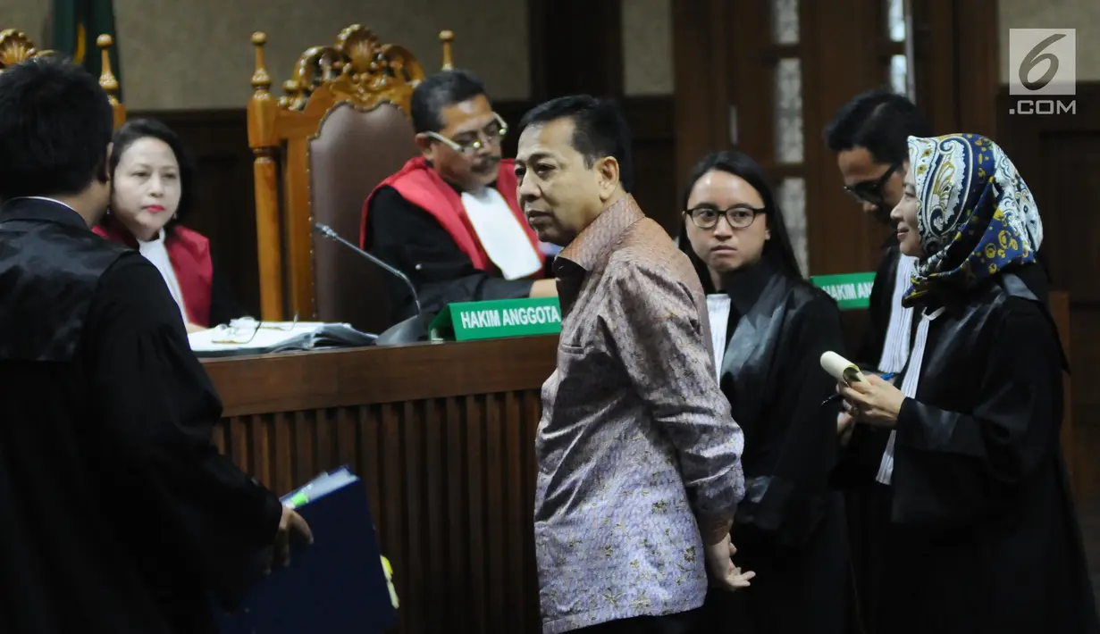 Terdakwa dugaan korupsi proyek e-KTP Setya Novanto (tengah) berdiri untuk diperlihatkan barang bukti saat sidang lanjutan di Pengadilan Tipikor, Jakarta, Senin (15/1). Sidang bergaendakan mendengar keterangan saksi. (Liputan6.com/Helmi Fithriansyah)