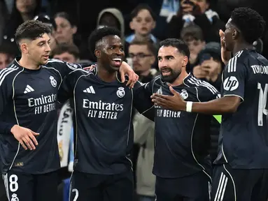 Penyerang Real Madrid, Vinicius Junior (kedua kiri) merayakan golnya pada pertandingan leg kedua 16 besar Liga Champions 2025/2026 melawan Manchester City di Etihad Stadium, barat laut Inggris, pada Selasa 17 Maret 2026 waktu setempat atau Rabu (18/3) dini hari WIB. Menang agregat 5-1 atas Manchester City, Real Madrid lolos ke perempat final Liga Champions 2025/2026. (Paul ELLIS/AFP)