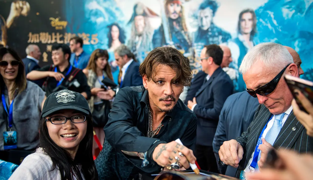 Seorang pengemar meminta tanda tangan Aktor Johnny Depp saat pemutaran perdana film Disney "Pirates of the Caribbean: Dead Men Tell No Tales"di Shanghai (11/5). (AFP Photo/Johannes Eiselle) 