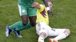 Aksi pemain Kolombia, Mateus Uribe (kanan) menghalau bola dari kaki pemain Senegal, Senegal, Idrissa Gana Gueye pada laga terakhir grup H di Samara Arena, Samara, Rusia, (28/6/2018). Kolombia menang 1-0. (AP/Gregorio Borgia)