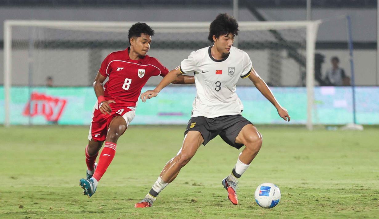 Bertanding di Indomilk Arena, Tangerang, Banten, Rabu (11/2/2026) malam, Timnas Indonesia U-17 kalah 2-3. Tampak dalam foto, pemain Timnas Indonesia U-17, Chico Jericho Yarangga (kiri) berebut bola dengan Zhao Songyuan (China) dalam laga uji coba di Indomilk Arena, Tangerang, Banten, Rabu (11/2/2026) malam. (Bola.com/Abdul Aziz)