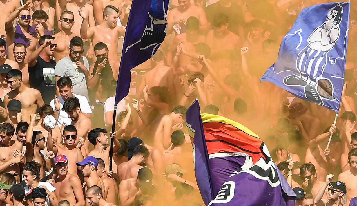Para suporter Fiorentina menyalakan flare saat melawan Juventus pada laga Serie A di Stadion Artemio Franchi, Florence, Sabtu (14/9). Kedua klub bermain imbang 0-0. (AFP/Vincenzo Pinto)
