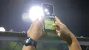 Seorang jurnalis tengah merekam latihan pemusatan latihan Timnas Indonesia U-20 yang berlangsung di Lapangan B, Senayan, Jakarta, Jumat (15/03/2024) malam. (Bola.com/Bagaskara Lazuardi)