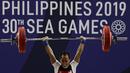 Lifter Suratman melakukan angkatan saat SEA Games 2019 cabang angkat besi nomor 55 kg di Stadion Rizal Memorial, Manila, Minggu (1/12). Dirinya meraih perak dengan total angkatan 250 kg. (Bola.com/M Iqbal Ichsan)