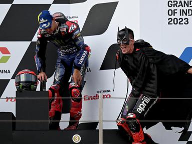 Pembalap Aprilia, Maverick Vinales (kanan) menggunakan kostum Batman saat berselebrasi di atas podium MotoGP Indonesia 2023 yang berlangsung di Sirkuit Mandalika, Lombok, NTB, Minggu (15/10/2023). Vinales berhasil merebut posisi kedua setelah finis di belakang Francesco Bagnaia. (AFP/Sonny Tumbaleka)