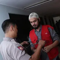 Petugas melepas borgol di pergelangan tangan Rio Reifan sebelum sidang digelar. (Galih W. Satria/Bintang.com)