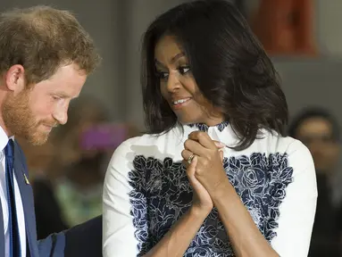 Pangeran Harry dan Michelle Obama berbincang saat menghadiri sebuah acara di Fort Belvoir, Virginia, Rabu (28/10). Pertemuan ini diadakan untuk mendukung pelaksanaan Invictus Games Orlando 2016 kepada para tentara yang terluka. (AFP PHOTO/SAUL Loeb)