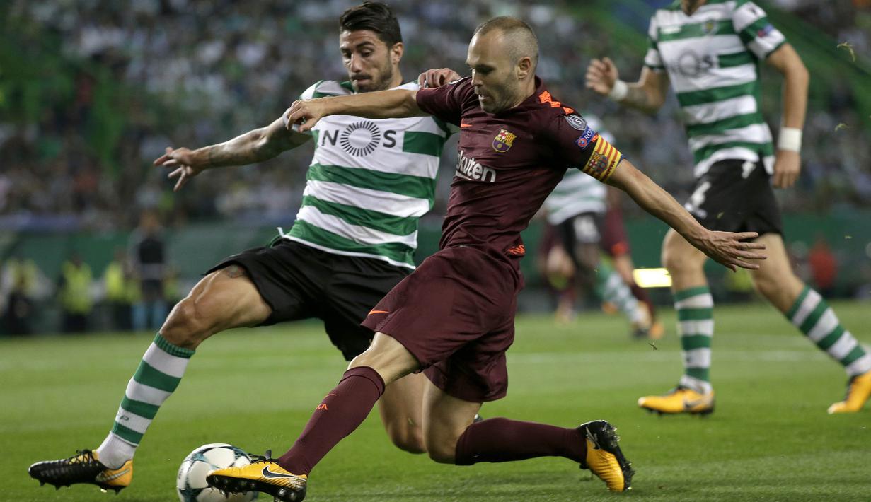 Gelandang Barcelona, Andres Iniesta, berusaha melewati bek Sporting Lisbon, Cristiano Piccini, pada laga Liga Champions di Stadion Alvalade, Lisbon, Rabu (27/9/2017). Sporting kalah 0-1 dari Barcelona. (AFP/Armando Franca)