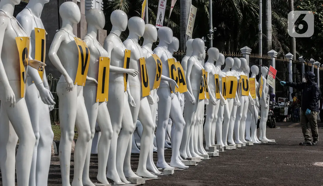 Aktivis Greenpeace Indonesia menyemprotkan disinfektan pada puluhan maneken saat menggelar aksi damai di depan gerbang kompleks DPR, Jakarta Pusat, Senin (29/6/2020). Aksi tersebut dilakukan sebagai bentuk penolakan terhadap RUU Omnibus Law. (Liputan6.com/Johan Tallo)