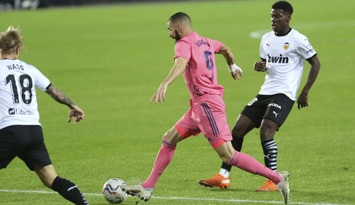Penyerang Real Madrid, Karim Benzema (tengah) mengontrol bola saat bertandang ke markas Valencia pada lanjutan La Liga di Stadion Mestalla, Selasa (9/11/2020) dinihari WIB. Real Madrid kalah telak 1-4 dari tuan rumah Valencia. (AP Photo/Alberto Saiz)