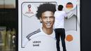 Seorang petugas menurunkan gambar Leroy Sane dari dinding museum sepakbola di Dortmund, (4/6/2018). Pelatih Joachim Low tidak memasukan nama Leroy Sane dalam skuat Der Panzer untuk Piala Dunia 2018. (Federico Gambarini/dpa via AP)