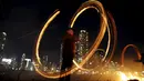 Warga memutarkan kaleng berisi kayu yang dibakar jelang perayaan "Jeongwol Daeboreum"di sebuah taman di Seoul, Korea Selatan, Minggu (21/2). Tarian api ini merupakan bagian dari perayaan Imlek ala Korea. (REUTERS/Kim Hong-Ji)