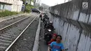 Pengendara sepeda motor melintasi jalan setapak di pinggir rel kereta di kawasan Tambora, Jakarta, Senin (10/7). Tidak tersedianya akses jalan untuk putar balik membuat warga terpaksa memanfaatkan jalan setapak tersebut. (Liputan6.com/Immanuel Antonius)