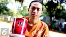 Seorang pedagang memperlihakan gelas bercorak tim Liga Italia, AS ROMA di Stadion Utama Gelora Bung Karno, Jakarta,Sabtu (25/7/2015) Para pedagang mengaku dagangan mereka laris jelang pertandingan AS Roma. (Liputan6.com/Helmi Afandi)