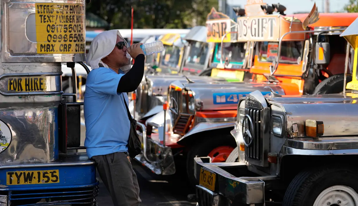 Seorang pengemudi jeepney beristirahat sambil minum air di terminal kota Pasay, Filipina, pada Senin, 23 Maret 2026. (AP Photo/Aaron Favila)